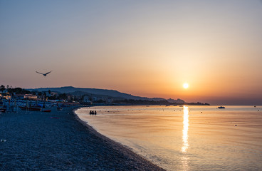 Obraz premium Beautiful Sunrise with orange sky and gold water. Calabria, southern Italy.