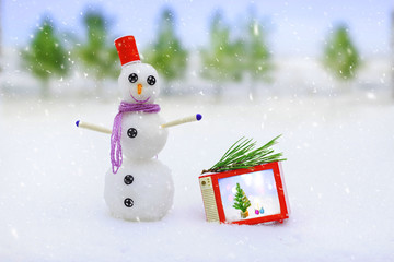 Smiling snowman and christmas decorations in the forest during a snowfall. Picturesque winter landscape. Holiday mood. Xmas and New Year fairy tale background. Beautiful greeting card. Magic nature.