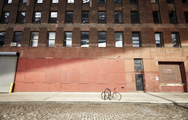 Locked bicycle on an empty street at sunset, New York City, USA..