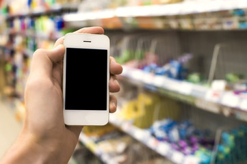 Fototapeta na wymiar Man hand holding mobile smart phone on Supermarket blur background, business concept