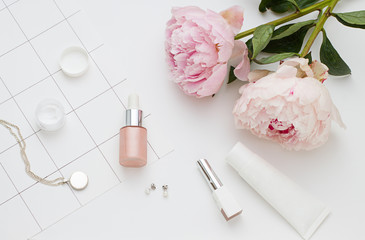 Beauty flat lay with cosmetic bottles and flower. Top view