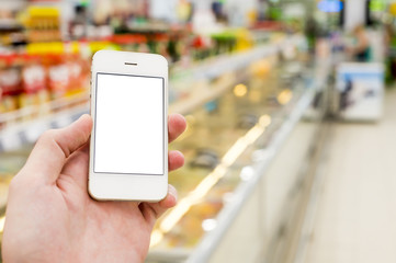 Man hand holding mobile smart phone on Supermarket blur background, business concept
