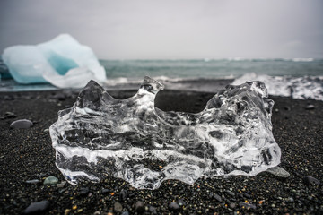 Ice sheet lying on a black beach in Iceland, ocean coast near Jökulsárlón - Glacier Lagoon.