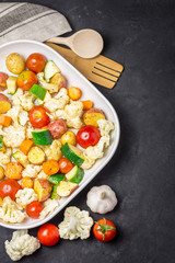 Various uncooked vegetables - tomatoes, cauliflower, zucchini, potato. Top view, space for text.