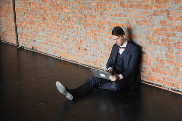 man using laptop in modern loft, professional businessman in suit working on new project with notebook computer while sitting at his office