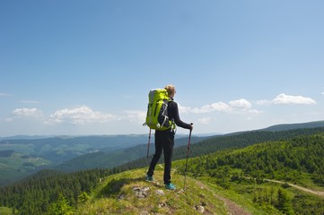 A young woman standing on top of a hill, preparing herself for the upcoming adventure. Beautiful...