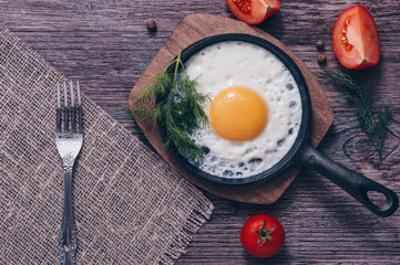 Scrambled eggs in a frying pan on wooden table,top view of a toning.