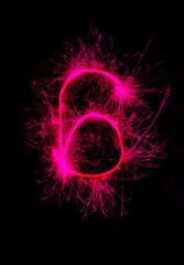 "6" number drawn with bengali sparkles isolated on black background,number from sparkler on black background