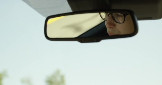 Woman driving and talking in rear view mirror - slow motion