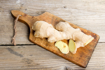 Raw ginger root on wooden background.