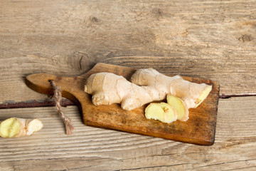 Raw ginger root on wooden background.
