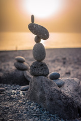 Skulpturen am Strand aus Steinen im Sonnenuntergang