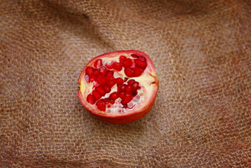 Pomegranate Cut Into Half Over Sackcloth