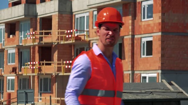 Construction worker is angry and shouts in front of building site