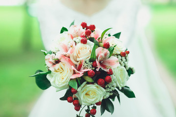 Beautiful bride in white wedding dress holding bouquet