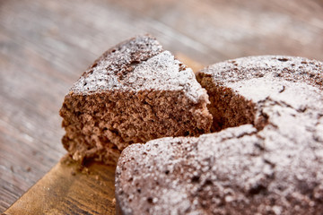 Delicious chocolate cake in white plate on wooden table background