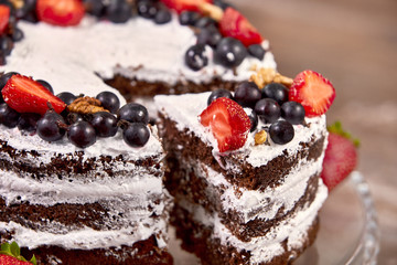 a cut of cake with whipped cream and strawberry fruits on wood table