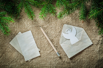 Fir tree twig envelope paper angel pencil on bagging surface