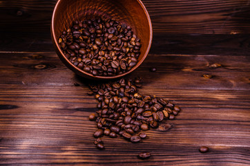 Roasted coffee beans in bowl on wooden table