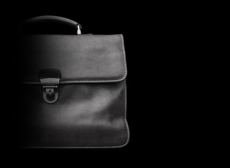 Expensive leather briefcase on a black background.