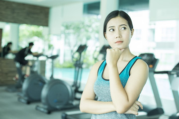 Fototapeta na wymiar Asian Beautiful Woman Thinking Somthing at Gym, Woman Exercise at Gym Concept.