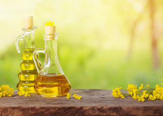 rapeseed oil (canola) and rape flowers on wooden table