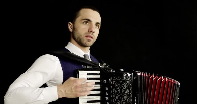 A musician in a white shirt plays the accordion.