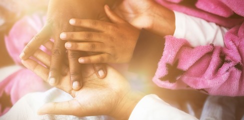 Family forming hand stack while playing on bed