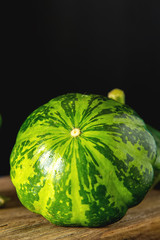 Healthy and delicious green patissons on a wooden board.. dark background. Vegetarian food.