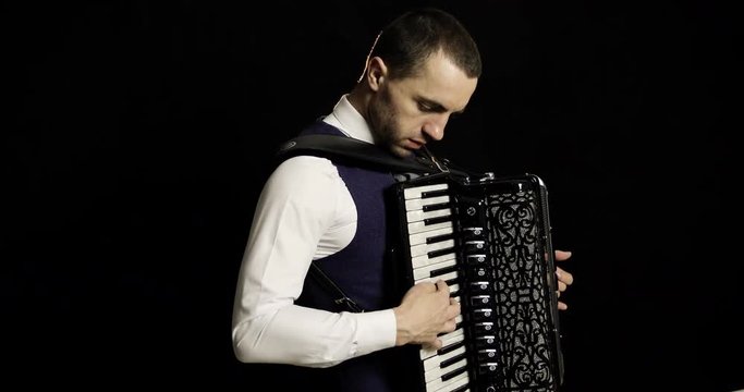 A musician in a white shirt plays the accordion.