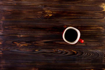 Cup of coffee on wooden table, top view