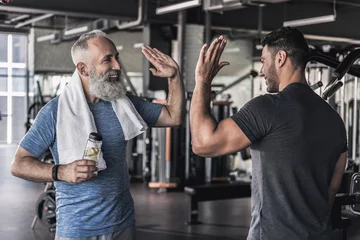 Keuken foto achterwand Fitness Vrolijke mannen praten met elkaar in de moderne sportschool