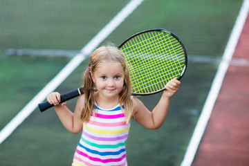 Child playing tennis on outdoor court