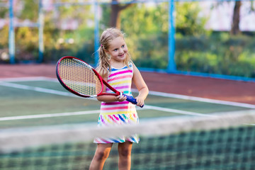 Child playing tennis on outdoor court