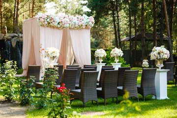 Beautiful wedding ceremony design decoration elements with arch, floral design, flowers and chairs.