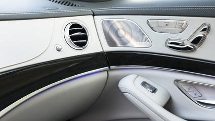 AC Ventilation Deck Luxury Car Interior. Door handle with Power seat control buttons of a luxury passenger car. White leather interior of the luxury modern car.