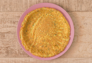 Round parmesan omelet in a pink plate.