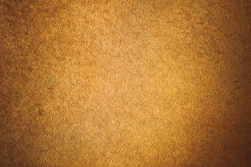 Old aged suede leather background. Coarse texture, gradient yellow brown beige, vivid colors. Vignette, toned.
