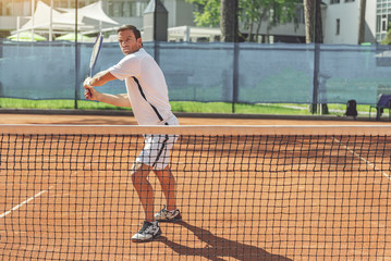 Obraz premium Serious man using racquet for game