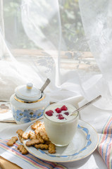 Milk yogurt in a transparent glass on the window background
