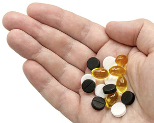 White, black and golden clear pills in your palm