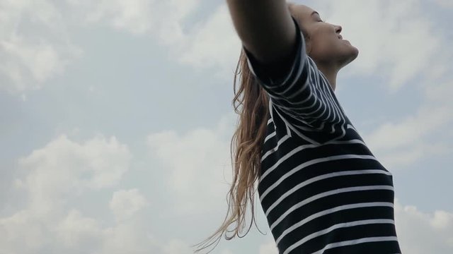 Happy woman turns on sky background in slowmotion