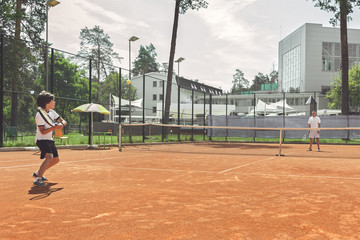 Boy playing game at court with man