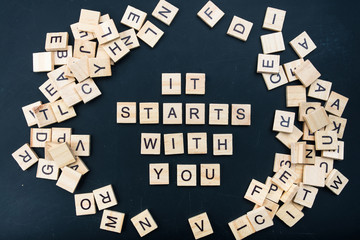 The letters on the black background form the text "it starts with you"