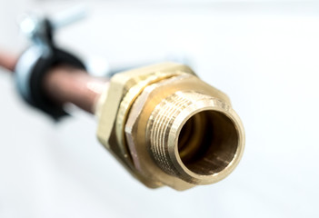 Bronze fitting is screwed onto a copper pipe.