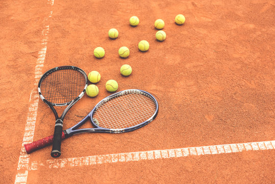 Necessary racquets beside yellow round spheres