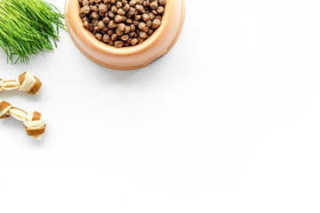 bowl full and overflowing with dry pet - dog food bits and toys on white background top view mock-up