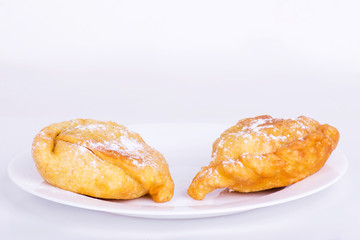 Two sweet samosa on a white plate
