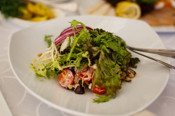 Mix fresh leaves of arugula, lettuce, spinach, beets for salad on a light stone background. Selective focus. Top view.
