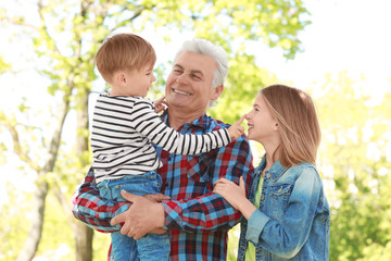 Fototapeta premium Cute happy children with grandfather in spring park